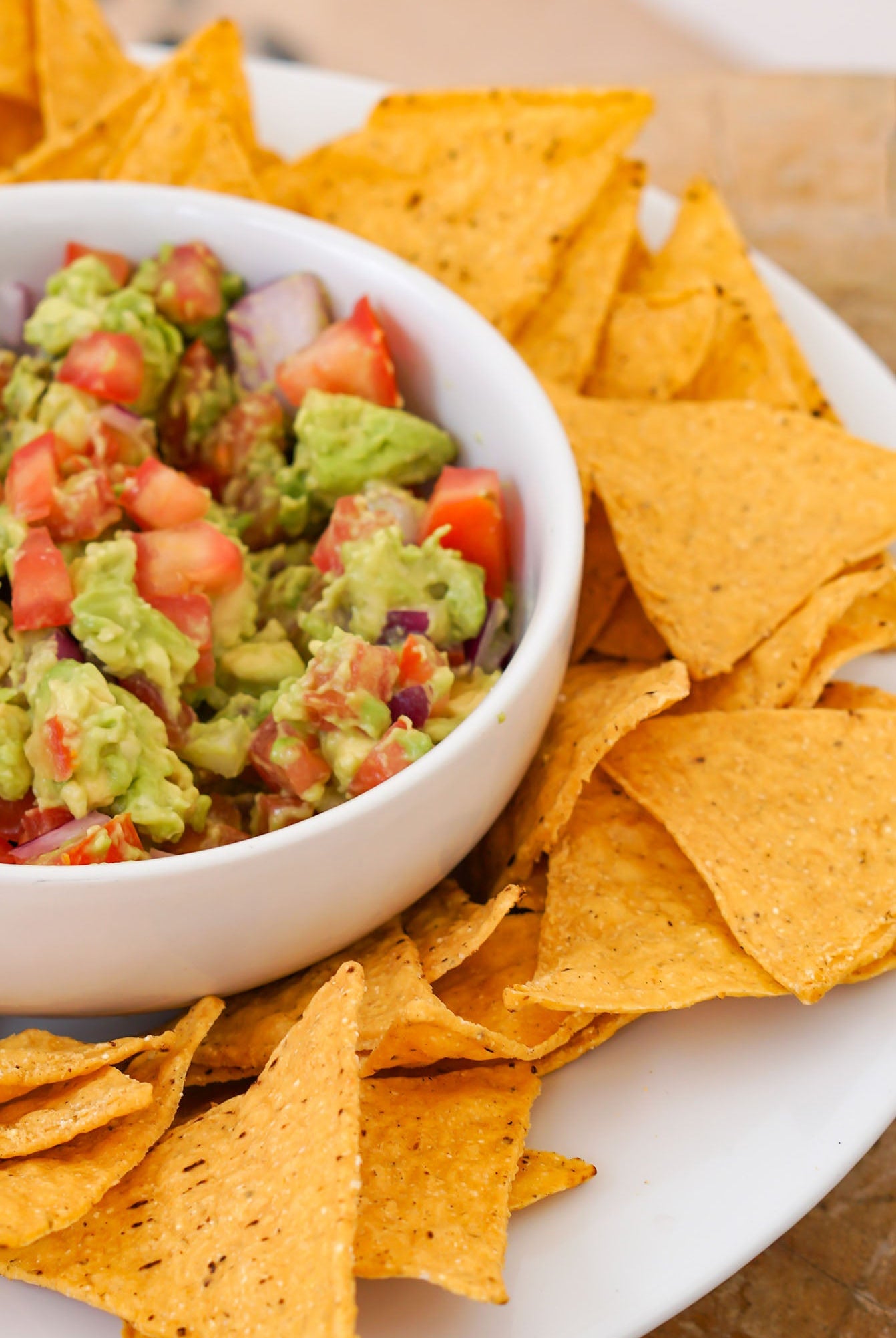Guacamole recipe from Love Fitness Apparel x Alyssa Marie. Photo features chips surrounding bowl of homemade guacamole.