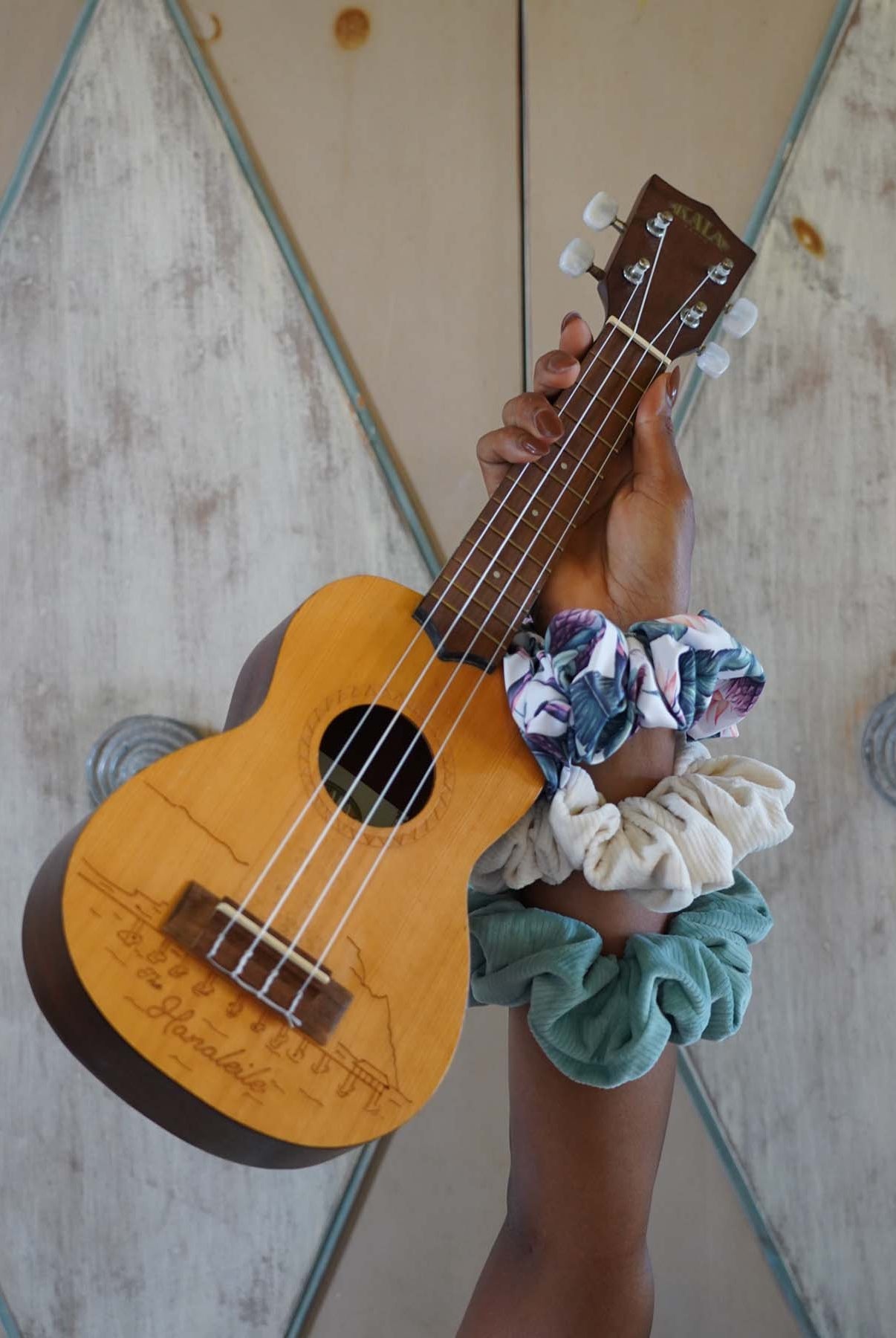 Arm holding ukulele with scrunchies on wrist