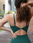 Love Fitness Dreamy Jumpsuit in the color evergreen. Close up detailing of the back adjustable straps and the beautiful metal heart detailing on the straps adjuster.