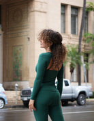 Free & Breezy Longsleeve - Evergreen model standing with her back towards the camera show casing the beautiful open back construction.