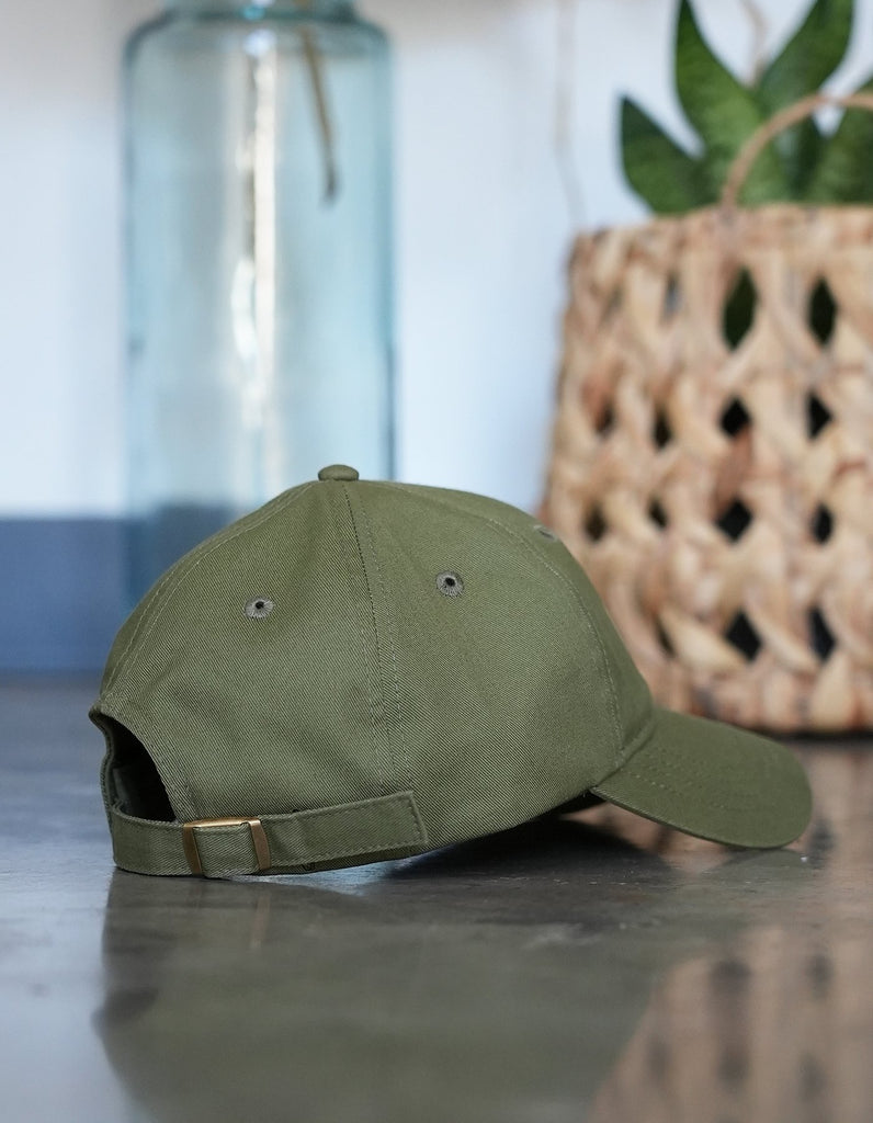 Love Fitness Apparel aloha dad hat in the color olive green. Showcasing the back and the beautiful bronze hardware on the adjustable strap