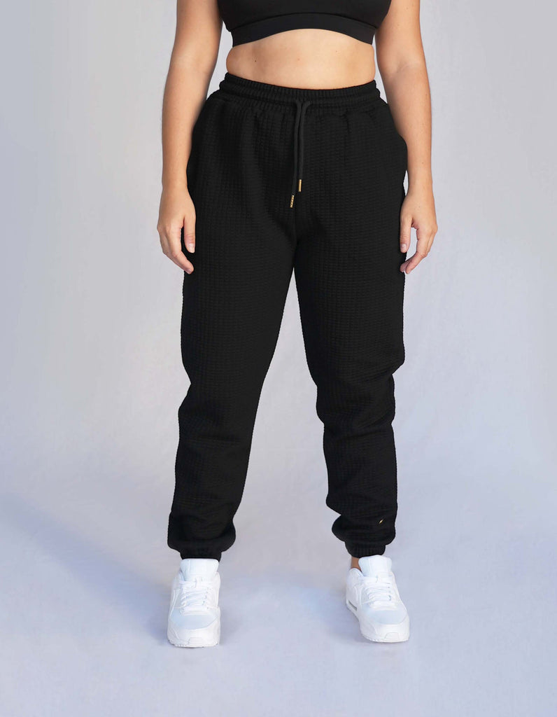 Love Fitness Phaedra Joggers in the color black. Waffle texture with pockets and drawstring to adjust the waistband.