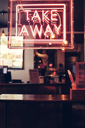 Photo shows a take out pink neon sign.