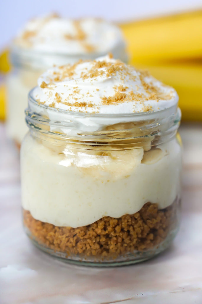 Banana Cream Pie Single Serving from Love Fitness Apparel x Alyssa Marie. Photo shows a jar with layers of graham crumbs, vanilla pudding, banana, and Cool Whip.