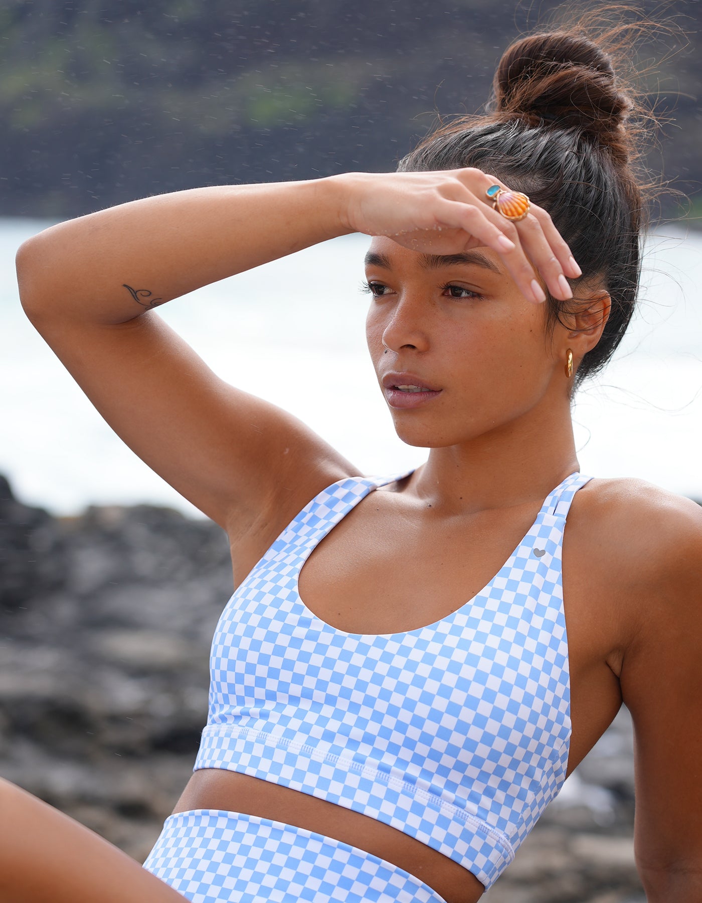 Love Fitness Effortless Pocket Shorts - Checkered Tidal Mist Woman wearing a blue checkered activewear set on a beach