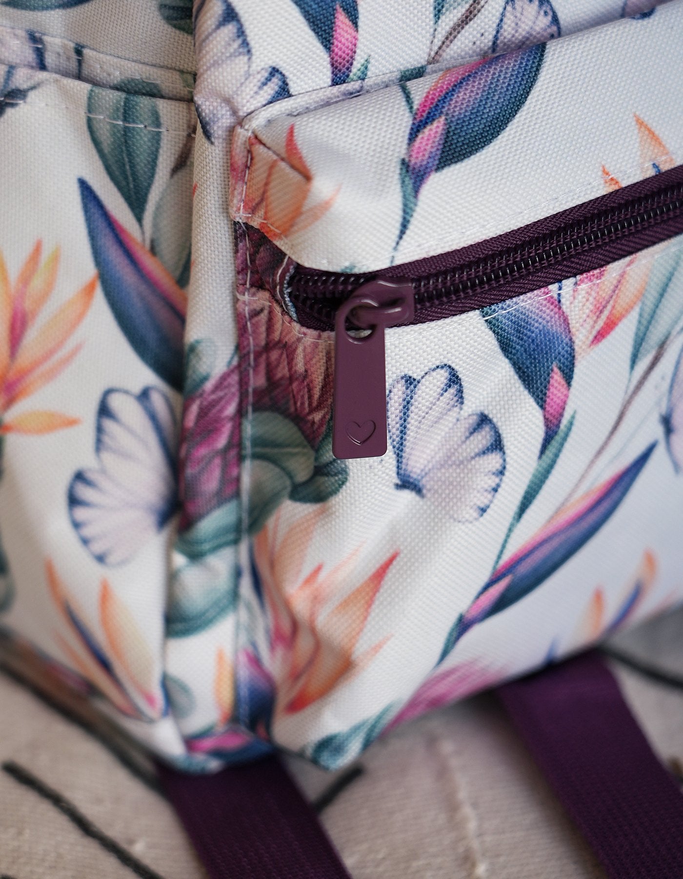 Love Fitness Island Dreams back pack with dark purple detailing and front zipper with zipper pull that has a cute heart detailing embossed into the zipper pull