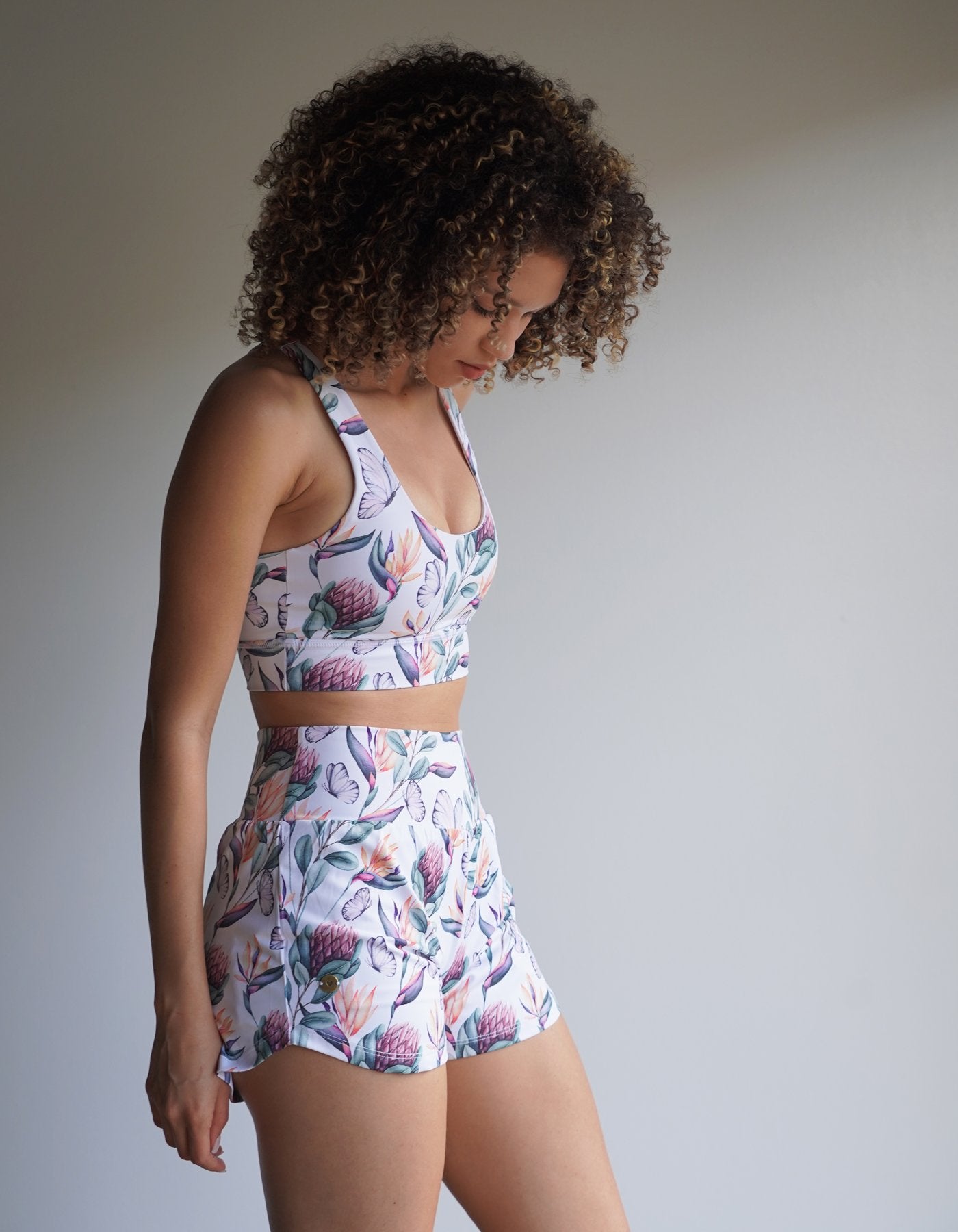 Love Fitness Apparel Island Dreams Sports bra with a gorgeous floral print and low scoop neck line. Model is also wearing the matching Island Dreams Runners