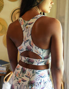 Love Fitness Apparel Island Dreams Sports bra. Showing a picture of the models back and the show cases the design of the back of the sports bra. Racerback and key hole opening.